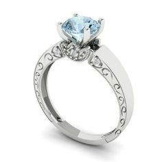 a white gold engagement ring with an aqua blue topazte and diamonds on the sides