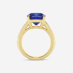 a yellow gold ring with a blue sapphire stone in the center and two diamonds on each side