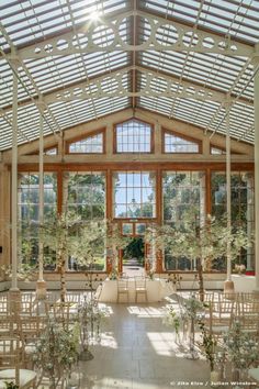 the inside of a large building with lots of windows and plants on either side of it