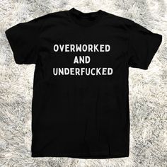 Introducing The T-Shirt That Speaks Your Truth Louder Than Your Boss Yells At You The "Overworked And Underfucked" Men's Tee! Crafted From 100% Pure Cotton, This Black Beauty Is Perfect For Those Who Need A Laugh As Much As They Need A Vacation. Wear It To The Office, The Bar, Or Your Next Therapy Session Wherever The Truth Needs To Be Told. Warning: This Shirt May Cause Spontaneous High-Fives And Knowing Nods From Fellow Sufferers. Funny Saying For Shirts, Sarcastic Shirts For Men, Black Relaxed Fit T-shirt With Funny Text, Black Slogan Shirt In Grunge Style, Black Relaxed Fit Funny T-shirt, Black Tops With Funny Text For Streetwear, Black T-shirt With Funny Text In Relaxed Fit, Black Crew Neck T-shirt With Funny Text, Funny Black Shirt With Letter Print