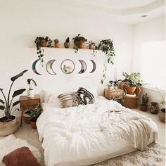 a bedroom with white walls and lots of plants