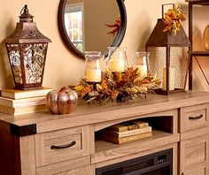 a mantle with candles and autumn decorations on it in front of a mirror, fireplace