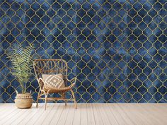 a chair and potted plant in front of a blue wall with gold circles on it