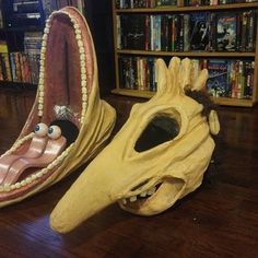 two shoes that are sitting on the floor in front of bookshelves and shelves