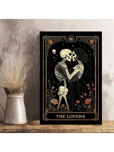 the lovers tarot card on a shelf next to a potted plant and vase