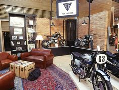 a motorcycle showroom with leather chairs, motorcycles and rugs on the floor in front of them