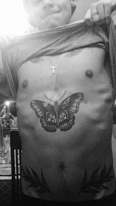 a man with a butterfly tattoo on his stomach and chest is holding onto a string