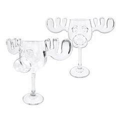 two wine glasses sitting next to each other on top of a white surface with one glass in the shape of a face