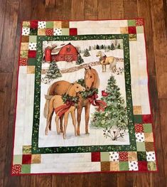 two horses standing next to each other in front of a christmas tree on a wooden floor