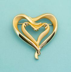 This gorgeous vintage gold tone heart brooch is perfect for everyday or special occasions. GENERAL DESCRIPTION  Vintage Double Heart Gold Tone Brooch. Color: Gold Tone Last photo includes measurements of the brooch If you have any questions please feel free to message me! Vintage Gold Heart Brooches, Gold Heart-shaped Brooch For Formal Occasions, Gold Heart Brooch For Formal Occasions, Gold Heart Brooch For Formal Wear, Elegant Gold Brooch For Valentine's Day, Elegant Gold Brooches For Valentine's Day, Vintage Gold Brooches For Valentine's Day, Gold Heart-shaped Brooches For Gifts, Gold Brooches For Valentine's Day