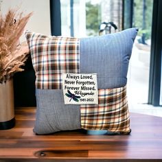 a pillow with a patchwork design on it sitting on a table next to a potted plant