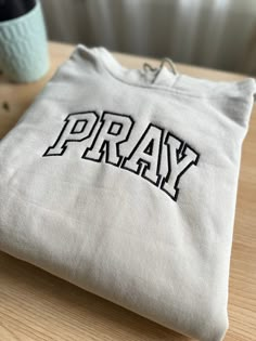 Pray embroidered sweatshirt. Pray sweatshirt embroidered on the neck are perfect for a perfect gift. The sweatshirt is crafted from a Gildan 8 oz. 50/50 cotton/polyester blend fleece. 👉 Don't wait! Get your mom a gift she'll treasure forever. CARE: Your sweatshirt is built to endure multiple washes, but for longevity, we suggest washing it inside out in cold water and tumble drying on low. If needed, use a medium iron, but avoid ironing directly over the embroidery. *PROCESSING TIME* We need 3 White Crew Neck Hoodie With Letter Embroidery, Custom Embroidered Crew Neck Hoodie For College, White Hooded Sweatshirt With Embroidered Text, White Embroidered Text Hoodie Sweatshirt, White Embroidered Hoodie Sweatshirt, White Embroidered Sweater For Streetwear, Embroidered White College Hoodie, Cotton Hooded Sweatshirt With Embroidered Text, White Hoodie With Embroidered Text For College