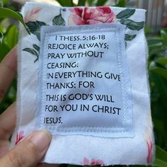 someone is holding up a piece of cloth with a verse on it