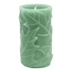 a green candle holder with leaves on it