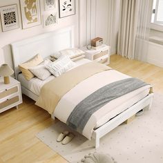 a bedroom with white walls and wooden floors has a bed, nightstands, and pictures on the wall