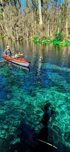 a man in a red boat on clear water