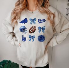 Coquette Bow Blue Sports Fan Cheer Sweatshirt, Football and Cheerleading Crewneck, Perfect Game Day Top, Gift for Sports Lover *Unisex Sweatshirt are Gildan *Medium-heavy fabric (8.0 oz/yd² (271.25 g/m *Loose fit *Runs true to size *50% cotton, 50% polyester SIZING This style is a unisex sweatshirt. If you are unsure about the size you should order, please refer to the size chart in the pictures. CARE INSTRUCTIONS * Machine wash: warm (max 40C or 105F) * Tumble dry: low heat * Do not iron direct Collegiate Blue Tops For Cheerleading, Blue School Spirit Tops For Cheerleading, Blue Tops For Cheerleading With School Spirit Style, Sporty Blue Tops For Cheerleading, Blue Cheerleading Top, Blue Team Spirit Sweatshirt For Sports Season, Blue School Spirit Sweatshirt For Fans, Blue Sweatshirt For Game Day With School Spirit, Blue Sweatshirt For School Spirit