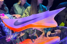 the nike shoe is on display in front of some people at a convention or event