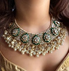 Adorn yourself with exquisite Bridal Kundan Jewellery in stunning shades of green and off white pearls. This Wedding jewellery, inspired by Indian and Pakistani traditions, features intricate designs including Jhumka earrings, Maangtika (forehead ornament), and Punjabi-inspired elements.  With vibrant ivory accents and green Meenakari work, this jewellery set is the perfect complement to your Indian wedding ensemble, radiating timeless beauty and capturing the essence of cultural heritage. Item includes: Necklace, earrings and maangtika Ready to be shipped with love from New Delhi, India  Please leave your phone number in notes or message when placing order for this item. Pista Green Jewellery Set, Luxury Green Bridal Necklace For Diwali, Luxury Green Meenakari Jhumkas, Elegant Green Lehenga With Stone Work, Chandbali Kundan Necklace With Pearl Drop, Kundan Chandbali Necklace With Pearl Drop, Kundan Pearl Necklace For Wedding Diwali, Bollywood Kundan Bridal Necklace With Pearl Drop, Kundan Pearl Necklace For Wedding