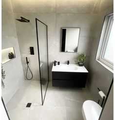 a bathroom with a sink, mirror and shower stall in the corner next to a toilet