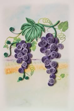 paper quilled grapes are hanging on the wall