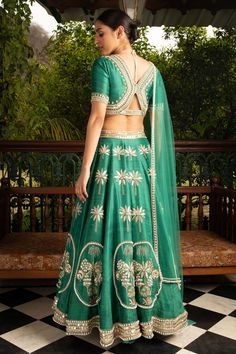 Editor's Note Green Lehenga Set In Raw Silk With Patchwork And Hand Embroidery In Raw Silk Patchwork. The Blouse Has A Flattering Neckline, Elbow Sleeves It Is Adorned With Statement Hand Embroidery. The Lehenga Skirt Has 14 Kalis And Is Adorned With Placement Patchwork And Hand Embroidery In Metallic Gold And Pearl. This Comes With Matching Sheer Net Dupatta With A Statement Hand Embroidered Border In Metallic Gold And Pearl Color: Green Fabric: Raw Silk, Net Care: Dry Clean Only About the Desi Buy Lehenga Online, Bridal Lehenga Online, Designer Bridal Lehenga Choli, Bridal Lehenga Designs, Bridal Lehenga Collection, Green Lehenga, Bridal Lehenga Red, Lehenga Online, Lehenga Choli Online