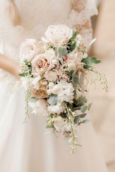 a bride holding a bouquet of flowers in her hand