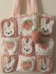 a crocheted tote bag hanging on a wall with bunny ears and carrots