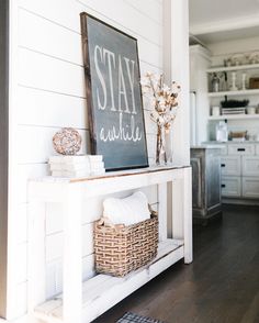 a sign that says stay awhile next to a basket with flowers and towels on it