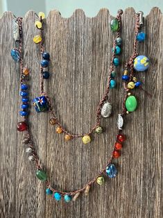 a multi stranded beaded necklace is displayed on a wooden surface