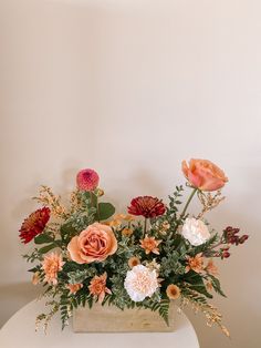 an arrangement of flowers in a vase on a table