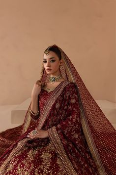 a woman in a red and gold bridal gown with her hands on her hips