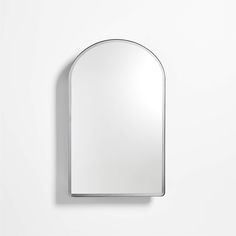 an oval mirror mounted to the side of a wall next to a white wall with a shadow on it