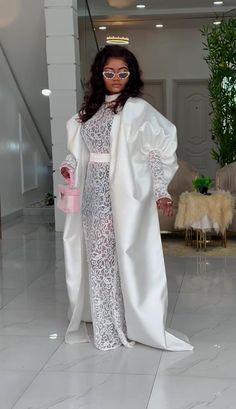 a woman is dressed in white and posing for the camera