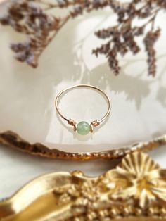 ✨ Dainty Light Green Jade Ring for Women ✨14K Gold Filled, Rose Gold Filled, Sterling Silver Wire Wrapped Tiny gemstone Ring💚 Simple stackable ring with a genuine green Jade, the good-luck stone. Jade is believed to bring protective, lucky-charm energy to the wearer 💚Sizing:• Gemstone Diameter: 4 mm• Ring Band: 0.8 mm • Handmade in your ring size with natural gemstone beads. • Dainty & cute. The ring is slim and petite, yet durable to wear daily. • Gold-filled is known for its lasting quality. Green 14k Gold Jewelry With Round Band, Green Promise Ring Jewelry With Round Stone, 14k Gold Filled Gemstone Ring, Dainty Green Round Jewelry, 14k Gold Filled Birthstone Ring, Green Crystal Ring For May Birthstone, Green Stackable Crystal Ring As Gift, Round Emerald Jewelry For Healing, Green Stackable Crystal Ring For Gift