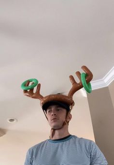 a man wearing an inflatable reindeer hat with two green rings on his head