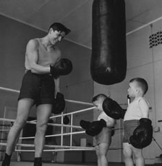 an old black and white photo of two young boys in the ring with boxing gloves