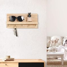 a wooden shelf with sunglasses on it next to a living room table and chair in the background