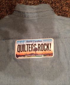 the back of a jacket with a sticker that says quilters rock on it