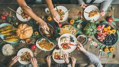 several people are sitting at a table with plates of food