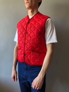 Quilted Waistcoat / Quilted Vest / Size M / 1990s  This vintage quilted vest wonderful condition! - made in Italy - ERA - circa 1990's - color - red - 2 outside pockets - 4 stud buttons at front - material - 100% polyester - label size - M (watch measurements) FLAT Measurements: Shoulders: 39cm Chest (underarm to underarm): 50cm Length(back): 62cm Pay your attention to that  most antique items have been used and may have minor flaws. Please , read the description carefully and check the measurem Vintage Cotton Quilted Jacket For Winter, Winter Vintage Cotton Quilted Jacket, Vintage Cotton Quilted Winter Jacket, Casual Quilted Cotton Vest, Quilted Vest For Winter Streetwear, Vintage Spring Vest Outerwear, Red Cotton Vest For Streetwear, Classic Red Sleeveless Outerwear, Fall Cotton Quilted Vest