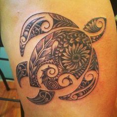 a turtle tattoo on the back of a woman's thigh, with an intricate design