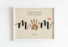 a framed print with the words mom and handprints in black, brown, and red