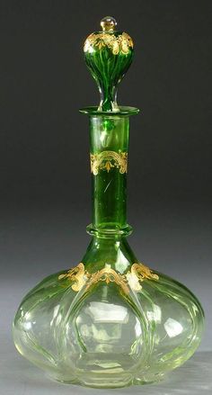 a green glass vase sitting on top of a table