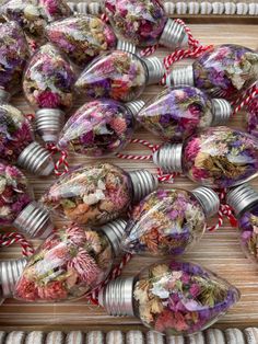 several tin can filled with dried flowers sitting on top of a table