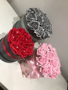 three boxes filled with roses on top of a white counter next to each other,