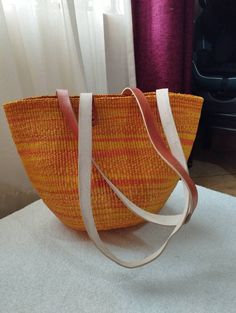 "Orange and yellow sisal tote bag DIMENSIONS Bottom width: 10\"/25.5cm Top width: 14\"/35.56cm Depth: 10\"/25.5cm Straps: 15\"/38cm SHIPPING All orders ship via DHL Express (3-5) days delivery time." Eco-friendly Hobo Bag With Leather Handles, Yellow Large Capacity Satchel For Summer, Summer Yellow Satchel With Large Capacity, Yellow Handheld Satchel With Large Capacity, Casual Handwoven Satchel Shoulder Bag, Eco-friendly Satchel Beach Bag With Adjustable Strap, Daily Use Bucket Satchel With Braided Handles, Daily Use Straw Shoulder Bag With Handles, Woven Double Handle Shoulder Bag For Shopping