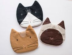 three different colored cat hats sitting on top of a white table next to each other