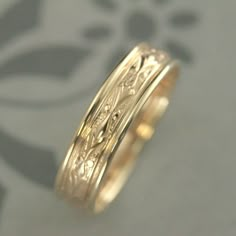 a gold wedding ring with intricate designs on it