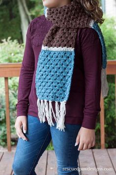 a woman wearing a crocheted scarf with fringes